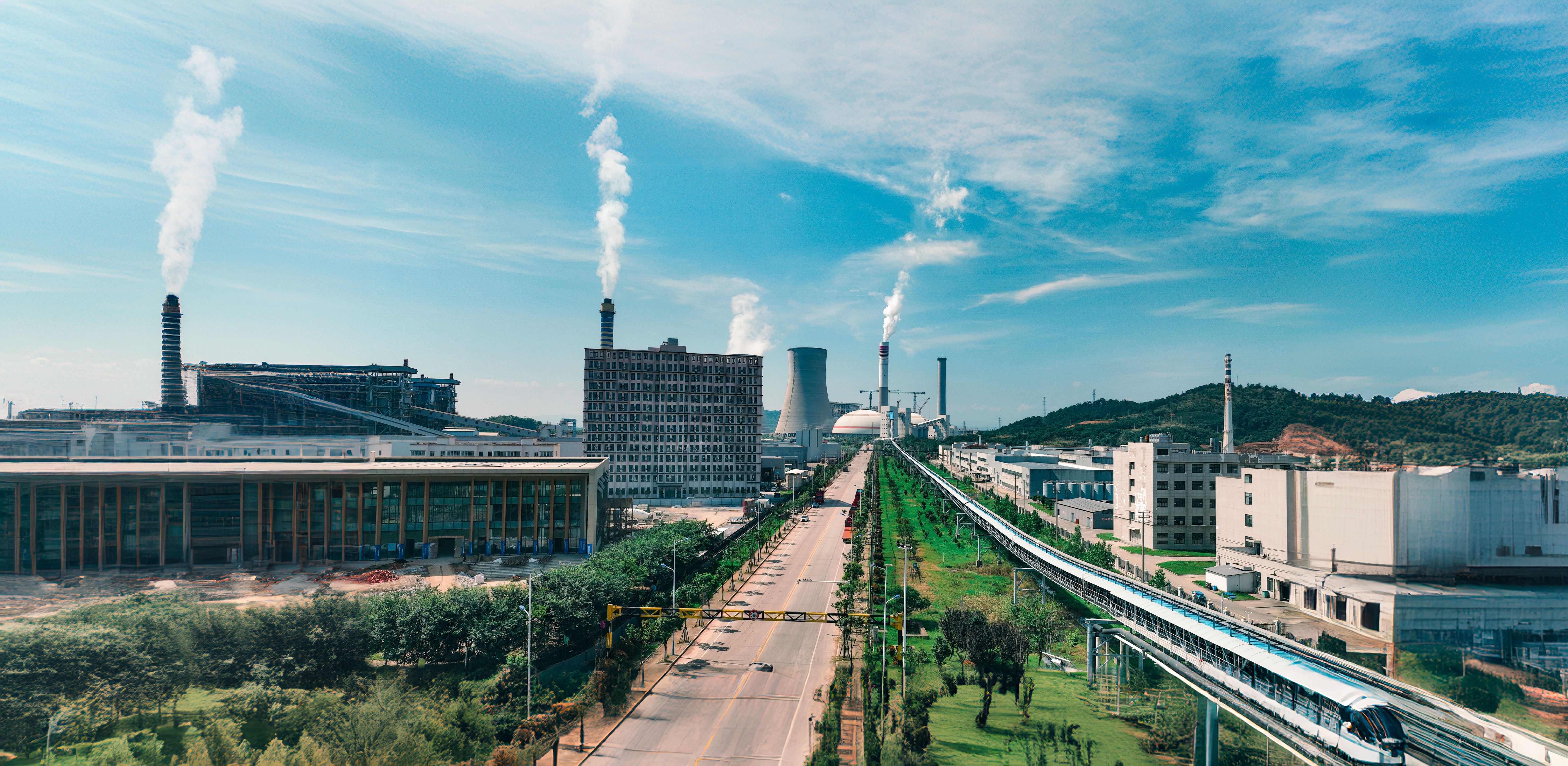 Industrial power plant with cooling towers beside a railway line