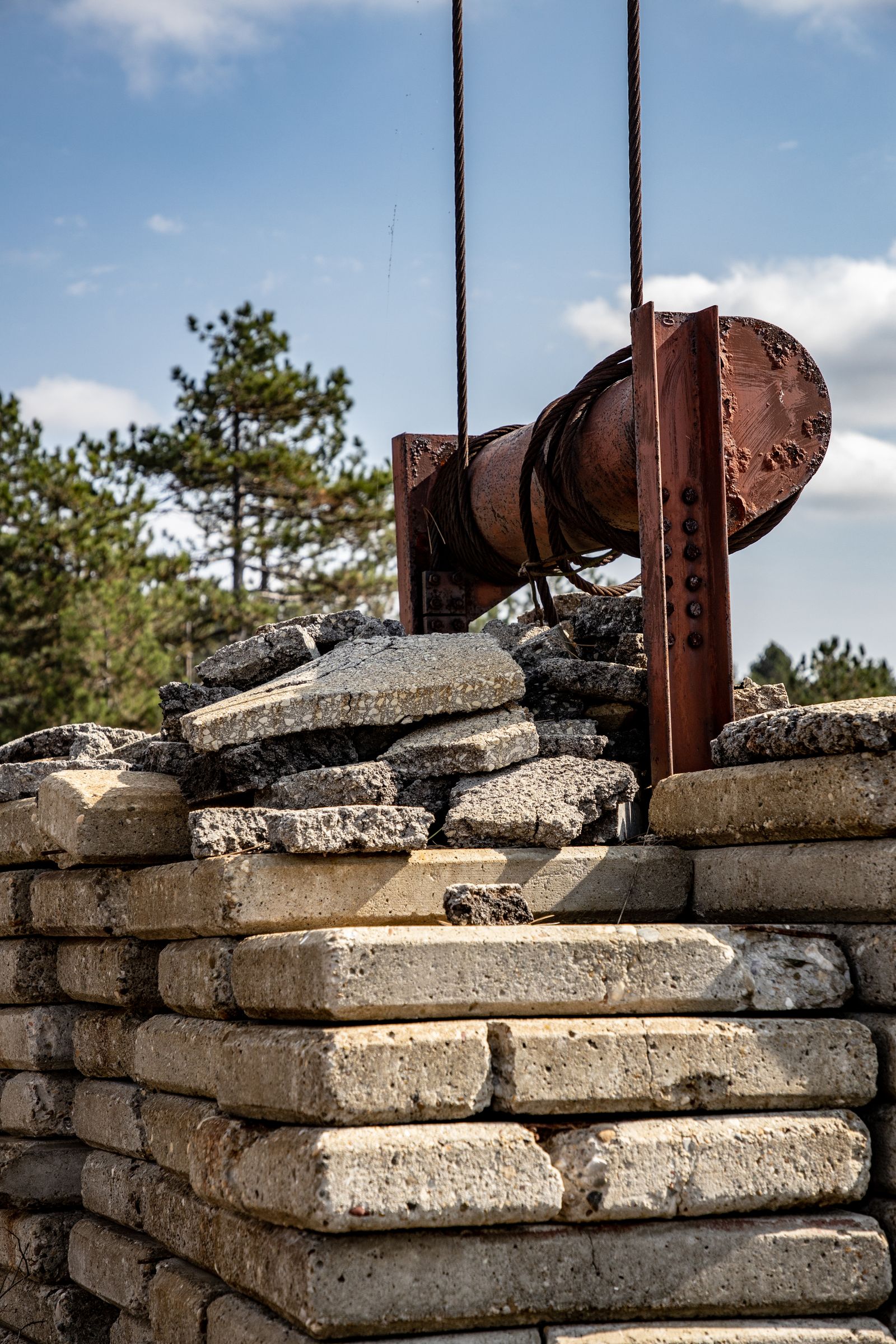 Stacked concrete blocks beside a rusted drum