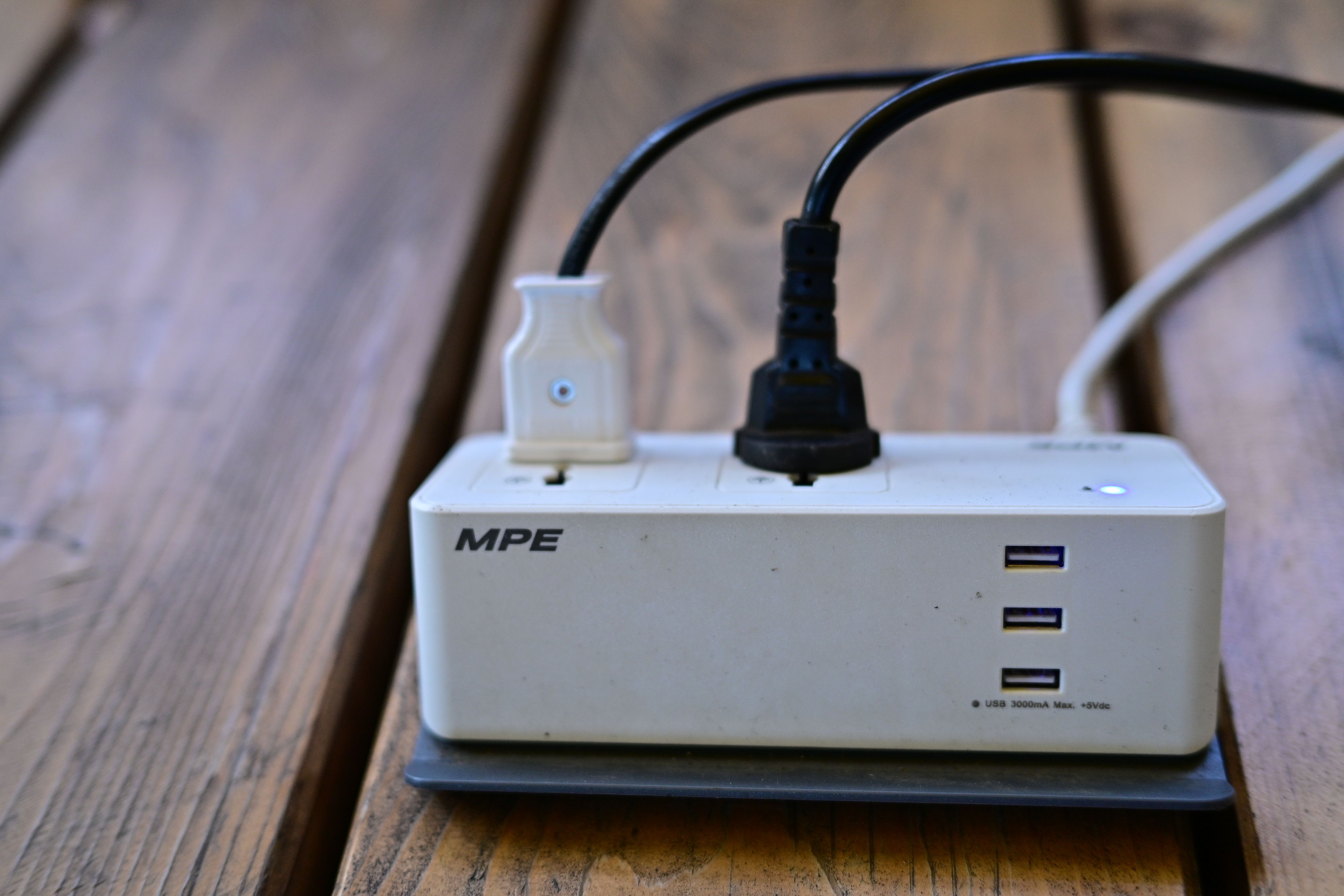 Multi-outlet extension socket with a plug on a wooden surface