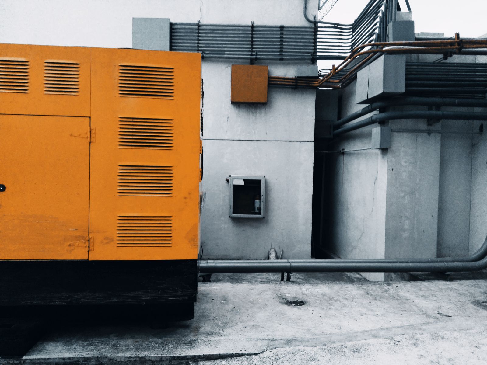 Orange industrial generator installed outside a building