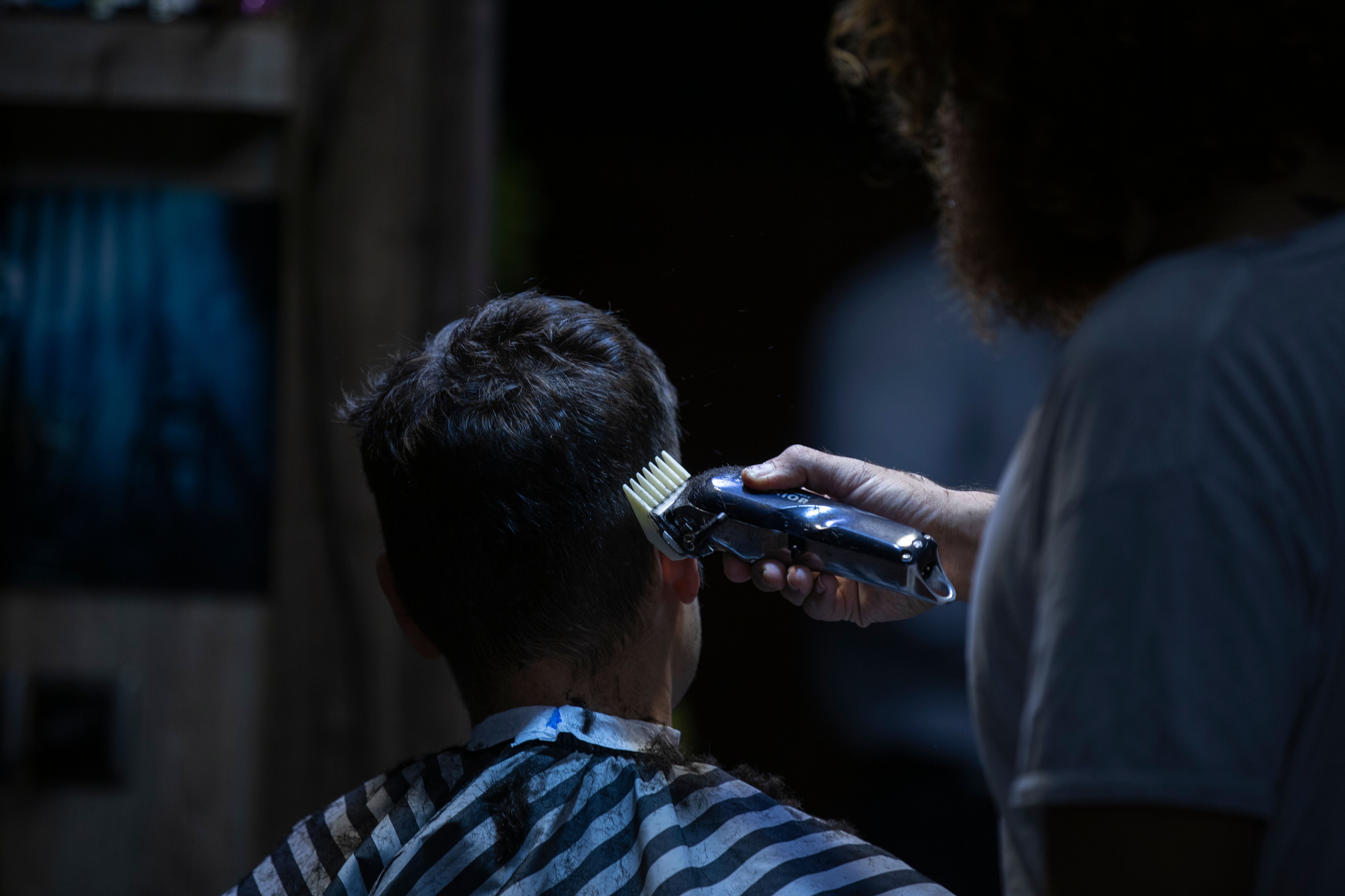 Barber using hair clippers on a client