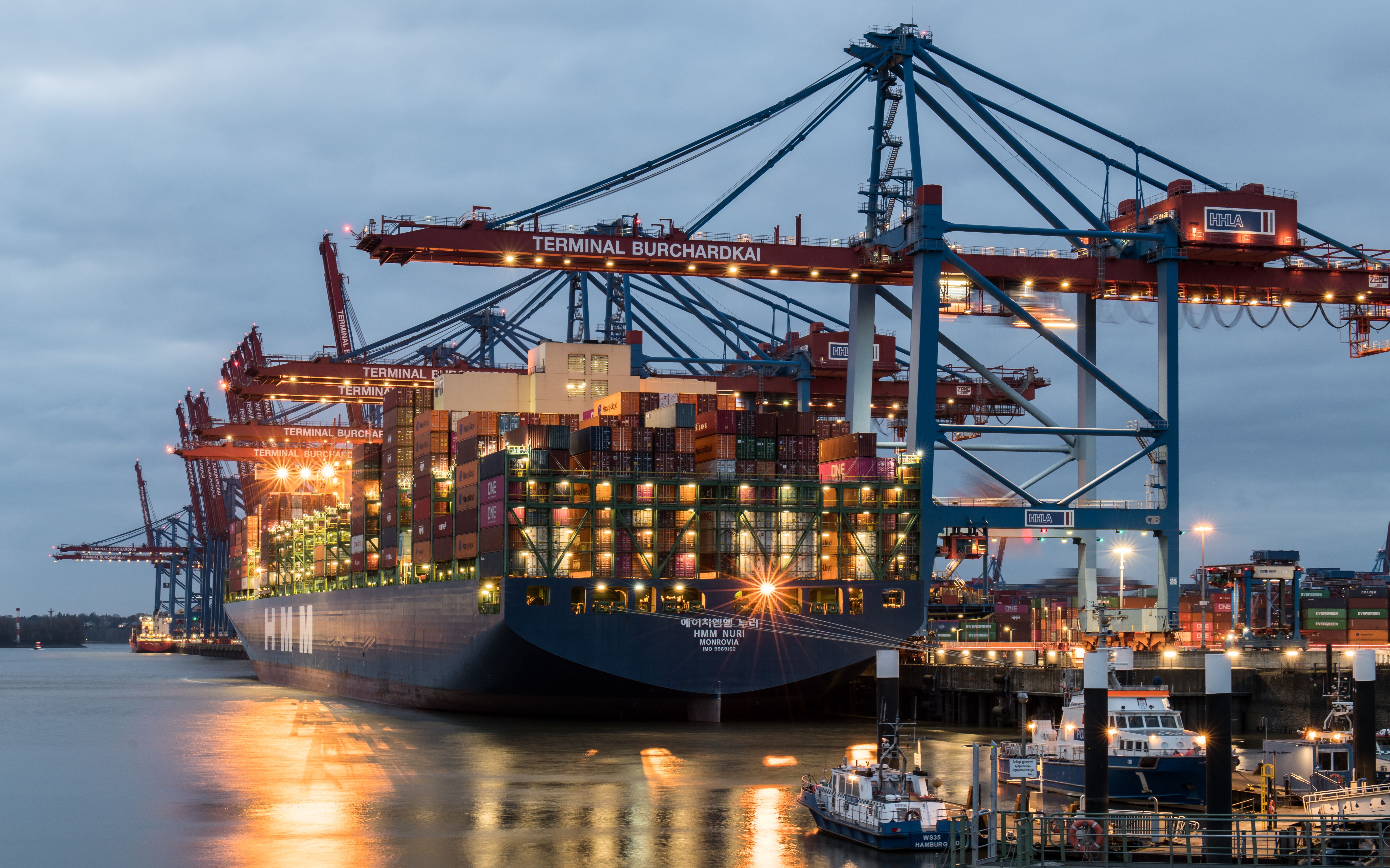 Container terminal at dusk with gantry cranes and ships