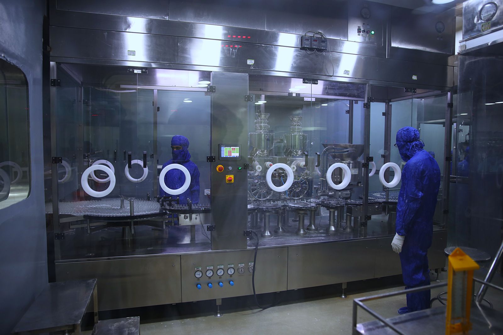 Operator in protective clothing working at a pharmaceutical isolator