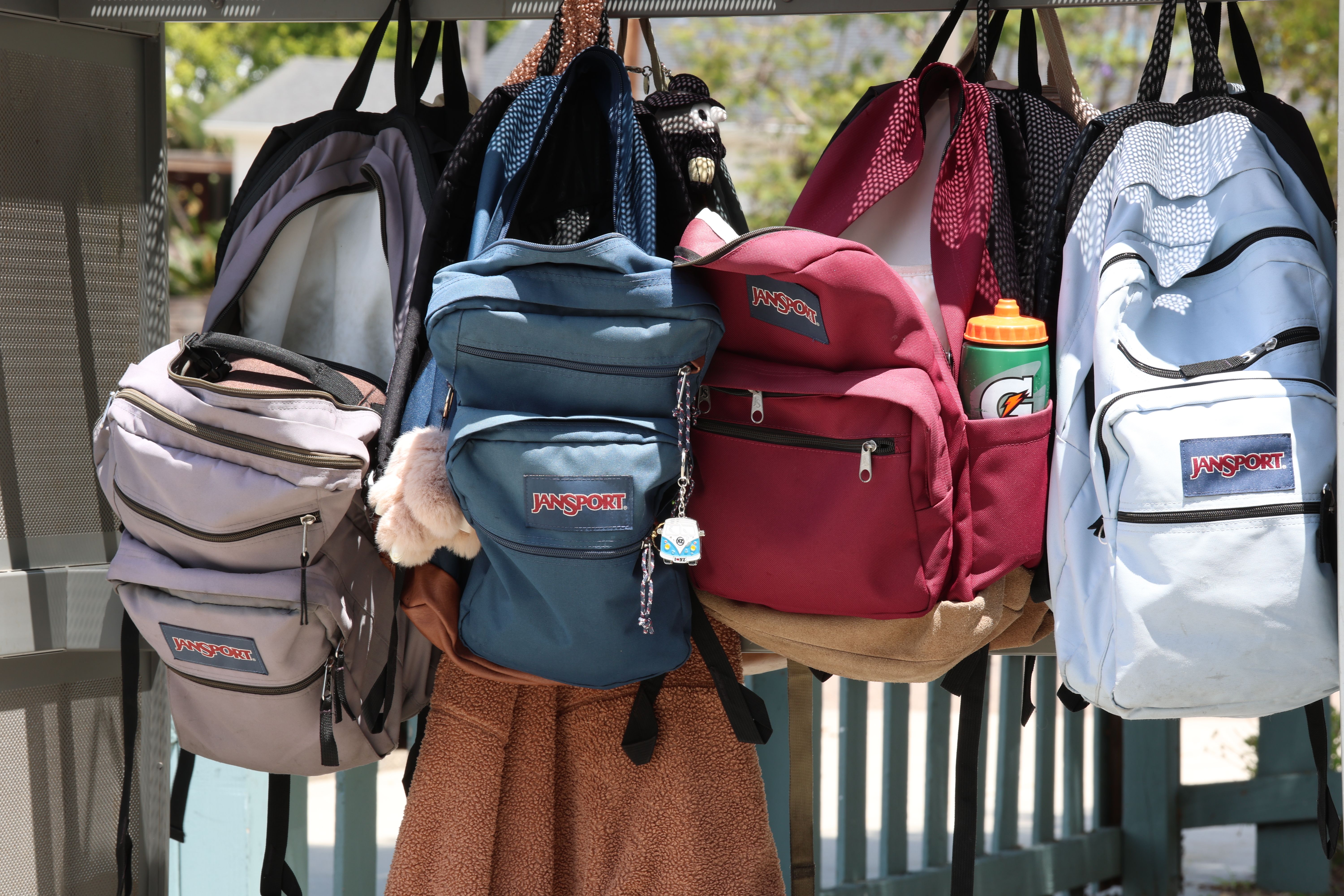 Row of school backpacks hanging on a rail