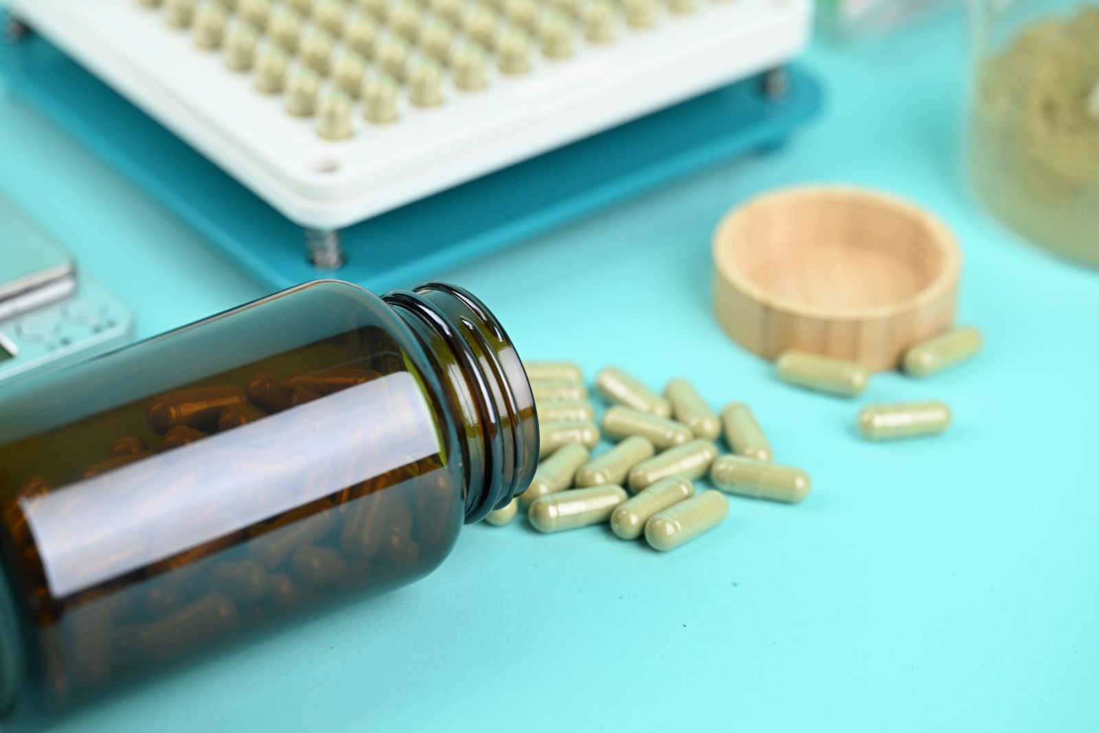 Capsules spilling from a bottle beside a blister tray