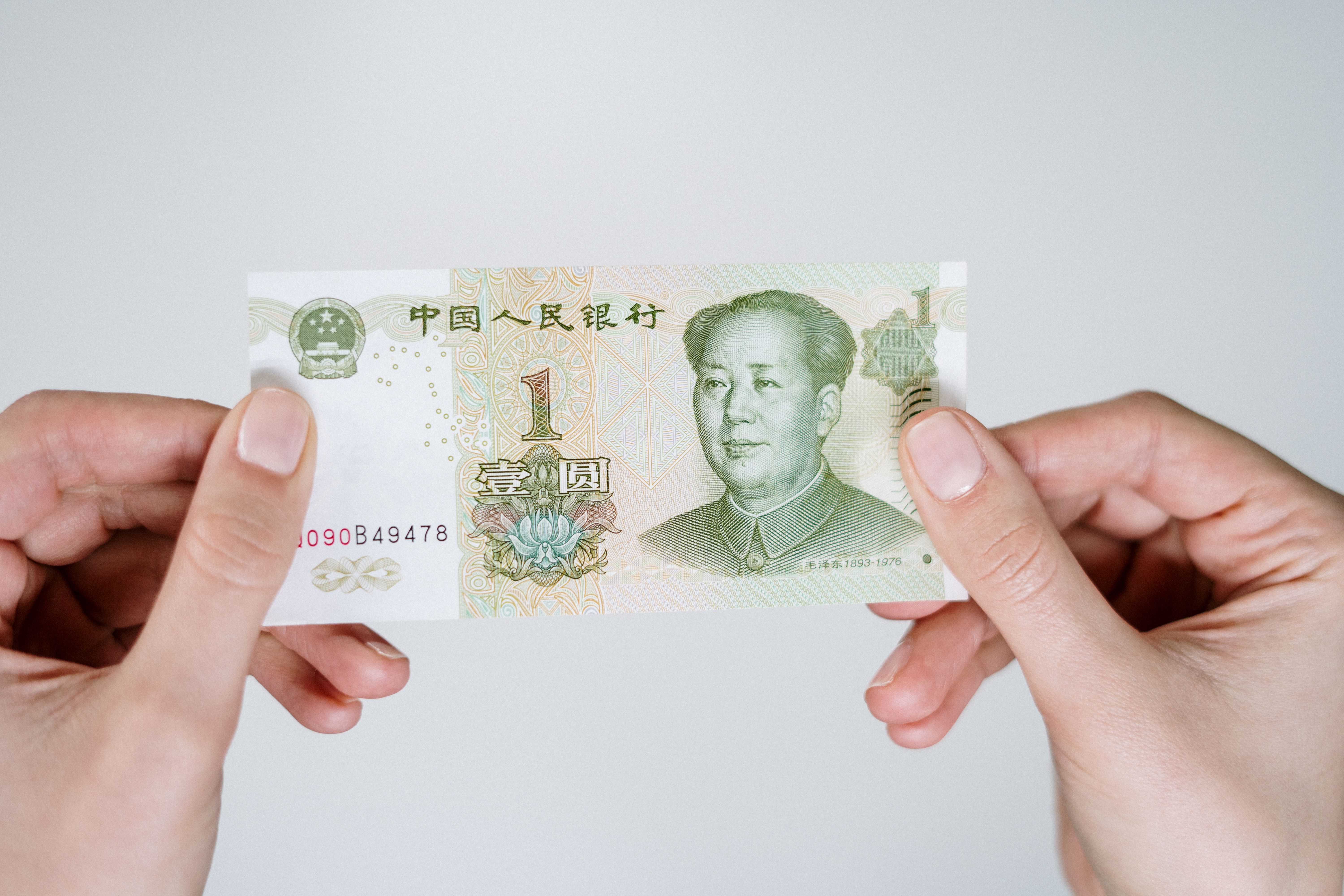 Hands holding a Chinese one yuan banknote