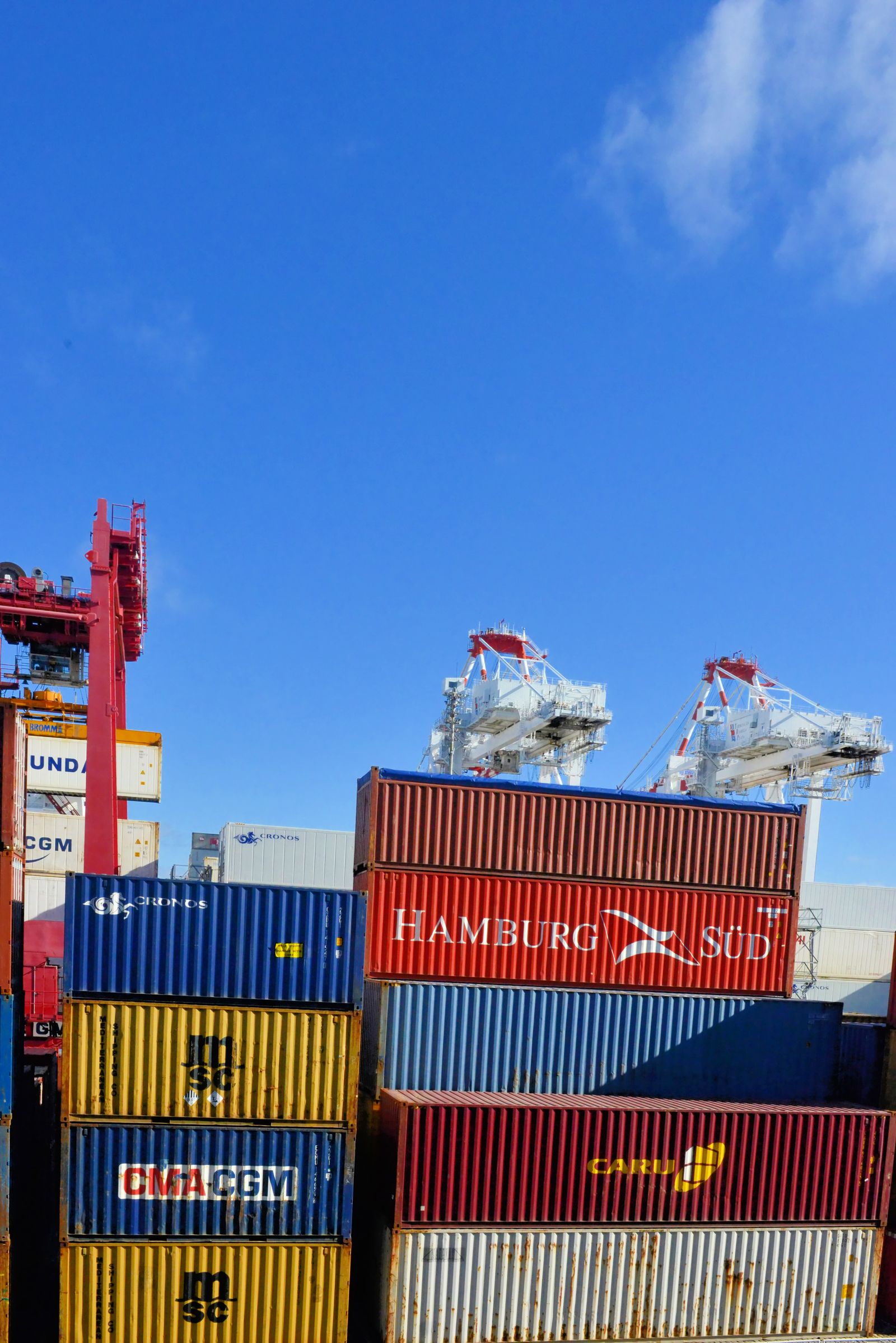 Stacked shipping containers and cranes at a container terminal